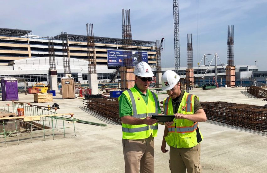 2 construction workers looking at an iPad