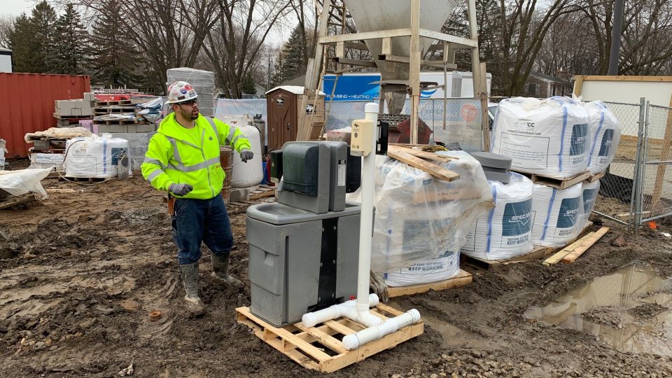 Construction worker at a hand washing station. Extra sanitizing measures are being taken on job sites to slow the spread of COVID-19.