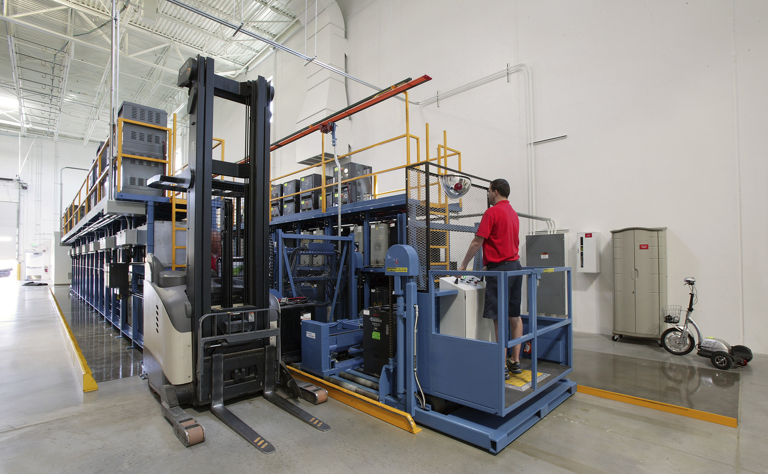 "Uline was begun in 1980 in the basement of the owners’ home. The first product offered was the H-101 carton sizer, which is still offered today. Uline has grown steadily since 1980 and continues to be a family owned and operated business. Today, with over 2,500 employees nationwide, Uline has distribution centers near Chicago, IL; Minneapolis, MN; Allentown, PA; Los Angeles, CA; Atlanta, GA; Dallas, TX; Seattle, WA; Tijuana, Mexico; Monterrey, Mexico and near Toronto, Ontario. The new Uline Distribution Warehouse, constructed by Kraus-Anderson, is located in Hudson, WI at Highway 35 and Hanley Road. The project was constructed on a 62.5 acre site. The 646,000 s.f. facility consists of 610,000 s.f. of warehousing with a 32’ clear height at the first column line and 36,000 s.f. of office space. The site development, including underground utilities, storm water ponds, erosion control, grading and landscaping was included in the scope of work. Exterior pavements include a concrete truck court area and bituminous parking areas. This building is a cross-dock warehouse with approximately 182 dock positions with parking for 200 additional trailers. Primary construction is IBC Type 2B, non-combustible, fully sprinklered, utilizing pre-cast concrete wall panels with steel structure and ballasted EPDM roofing over metal deck. Uline stores contents that are classified as Commodities I-IV per the NFPA 1 Fire Code, necessitating ESFR sprinkler coverage in the warehouse. The office space is two stories in height, with a pre-cast concrete plank 2nd floor supported on a structural steel frame, plus structural steel roof framing. One hydraulic elevator provides accessibility to 2nd floor with parking for 250 employees."