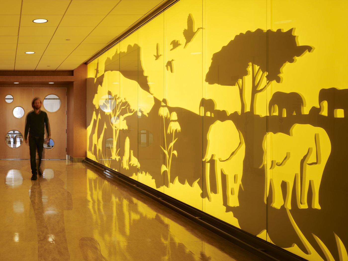 "Kraus-Anderson has completed this large healthcare project that involves construction of a new 6-story, 96-bed patient tower plus penthouse (230,000 s.f.); OR/ED expansion (30,000 s.f.); existing space renovation (50,000 s.f.); and 3 stories of underground parking for 180 cars. The 7-story Amplatz Children’s Hospital patient tower includes kidney dialysis, a pediatric intensive care unit, a floor for bone marrow transplants, general patient rooms, linear accelerator, sedation rooms, support services, a coffee shop, a gift shop and a mechanical penthouse. A new linking structure has been built between the campus’s existing East Building and the new Amplatz Children’s Hospital. The link contains new OR and ED Departments as well as a Doctor’s Lounge. The new OR Department is aimed primarily at children and contains six new Operating Rooms. Four of them will be utilized right away; the other two are shelled out for future use. Each OR has a different function including one for head injuries and one for neurosurgery. The department also has a large sterile supply area and a sterilization room. The ED Department will serve both children and adults. There is a walk-in Emergency Entrance, and an Ambulance Entrance. There is also a triage room. The ambulance garage has a break room for EMT Technicians, an MRI room, and a Decontamination Room with showers for victims of exposure to radiation or hazardous chemical spills. The water from these showers goes into a special disposal tank. The ER patient area features a long admitting area desk and four types of private emergency treatment rooms.  There is a special psychiatric lock-up room, trauma rooms for the most pressing cases, isolation rooms for people admitted with infectious diseases such as tuberculosis, and regular emergency treatment rooms. The 50,000 s.f. remodeling of a portion of the existing East Building involves a complete renovation of radiology, cardiovascular services, and PACU Pre/Post Services."